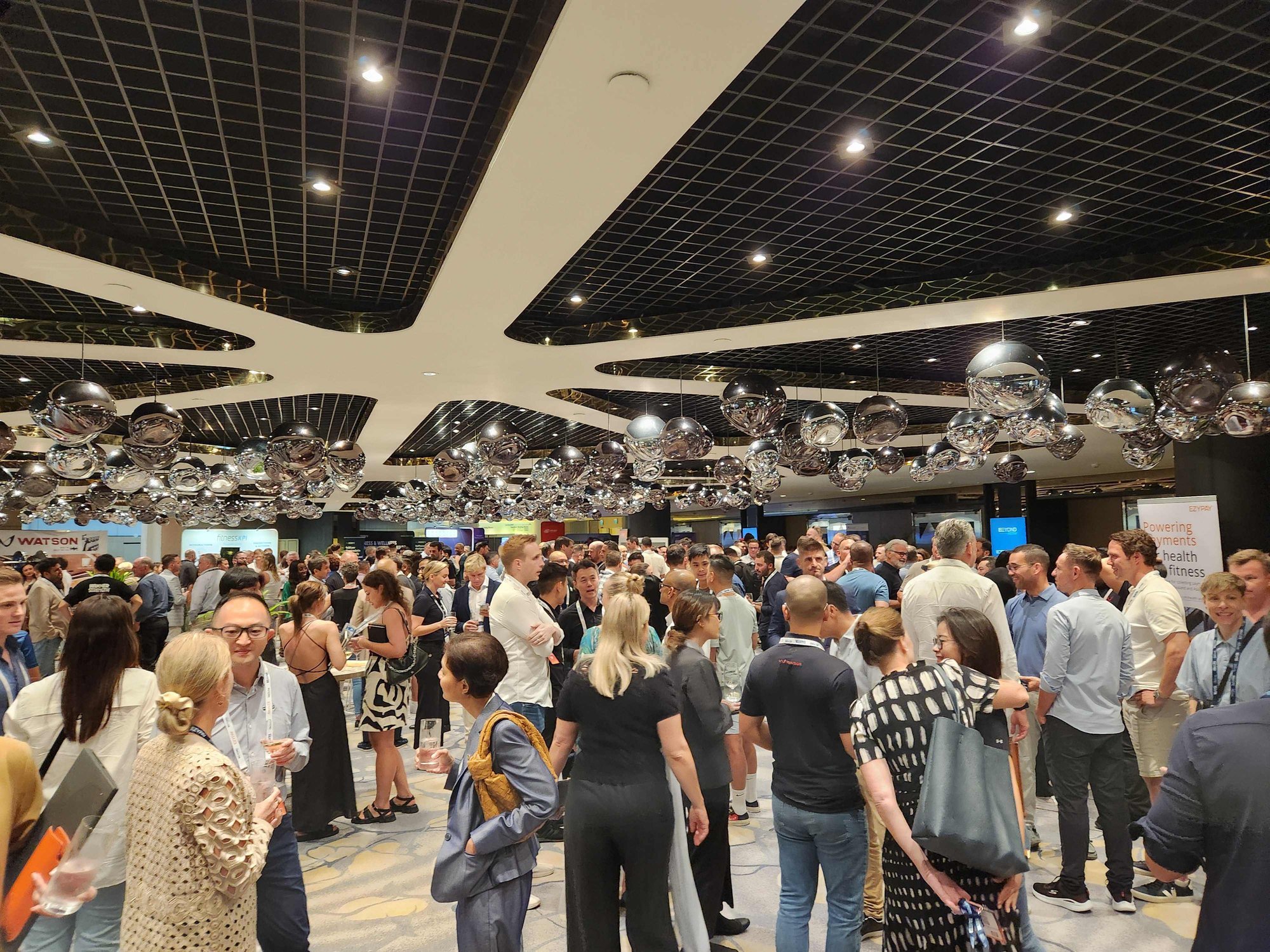 A conference room full of people at the Beyond Activ World 2024 Welcome Drinks (sponsored by Ezypay)