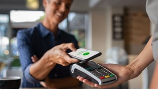 someone making a contactless Google Pay payment with their smartphone and a POS terminal